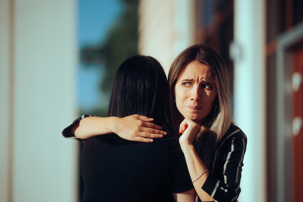 
Woman Hugging her Friend Having Mixed Feelings About Her
Girl uncomfortable with a stranger meeting and hugging her
