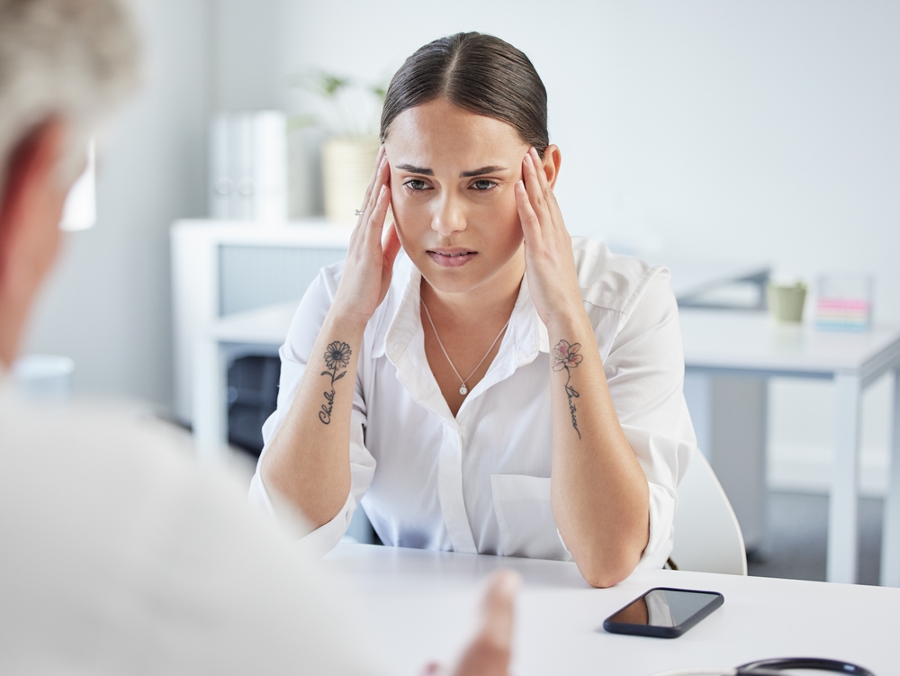 Woman, doctor and stress in consultation at hospital for results, report or information for wellness. Person, worry and listen with anxiety for infertility, care and advice for questions in clinic