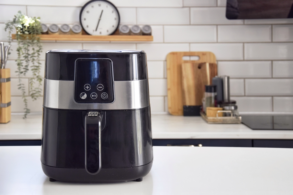 Black oil-free fryer in the kitchen.  Cooking in an air fryer without oil.Healthy food preparation.