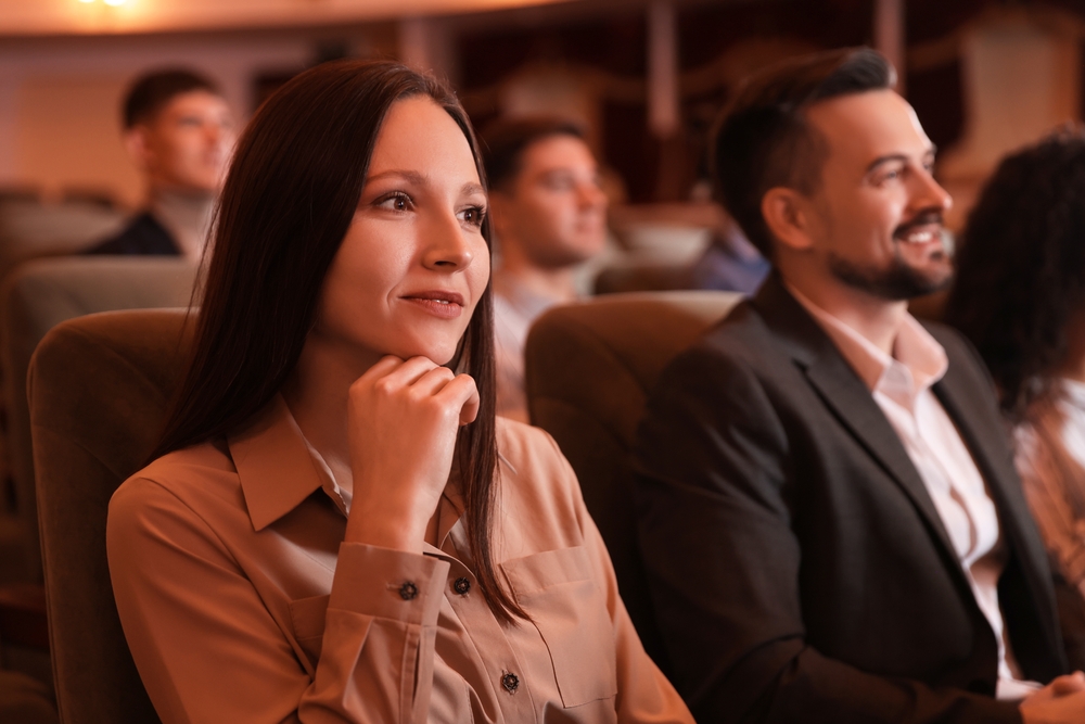 Group of people watching theatrical performance in theatre