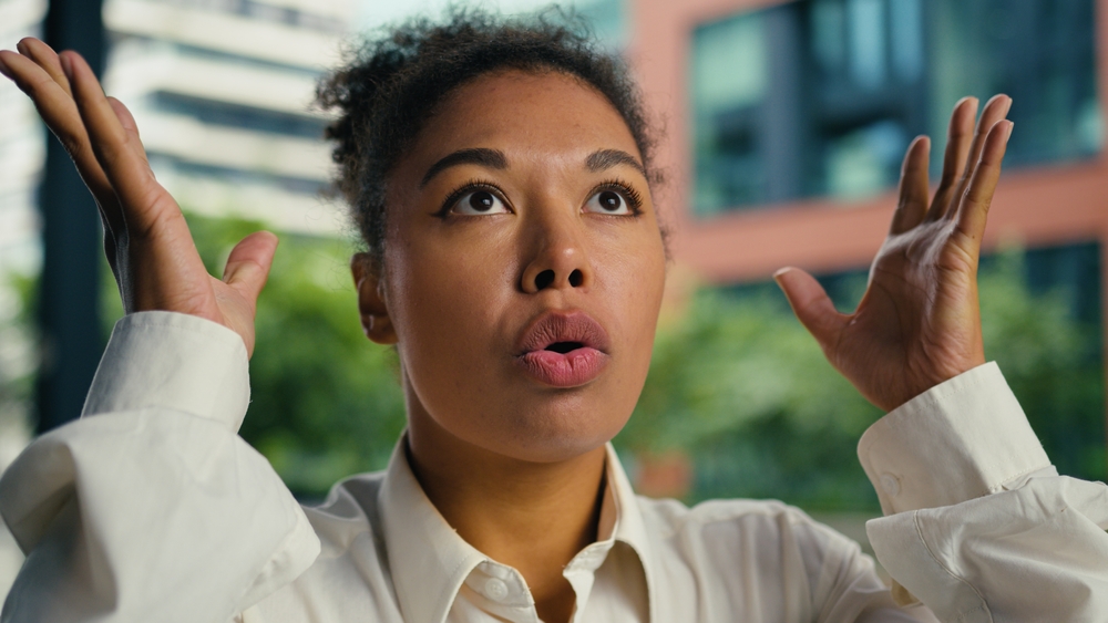 Excited African American woman surprised wow businesswoman showing hands female brain explosion head mind blow girl emotions shocked shock news overload gesture headshot city business crazy outside