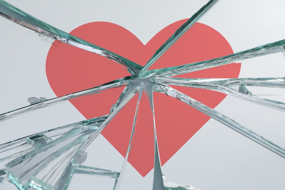 Betrayal. Broken glass with red heart, closeup