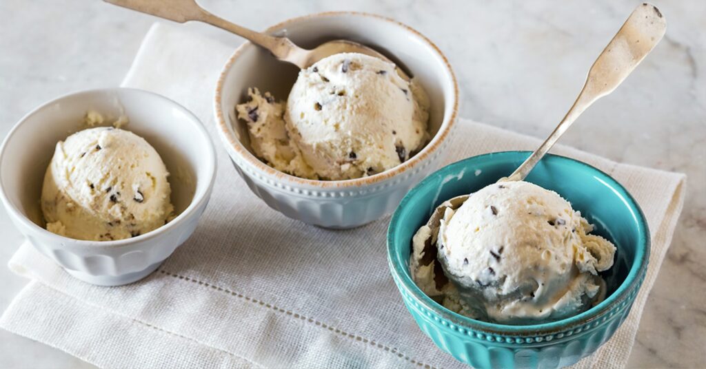 Three bowls of chocolate chip ice cream with spoons.