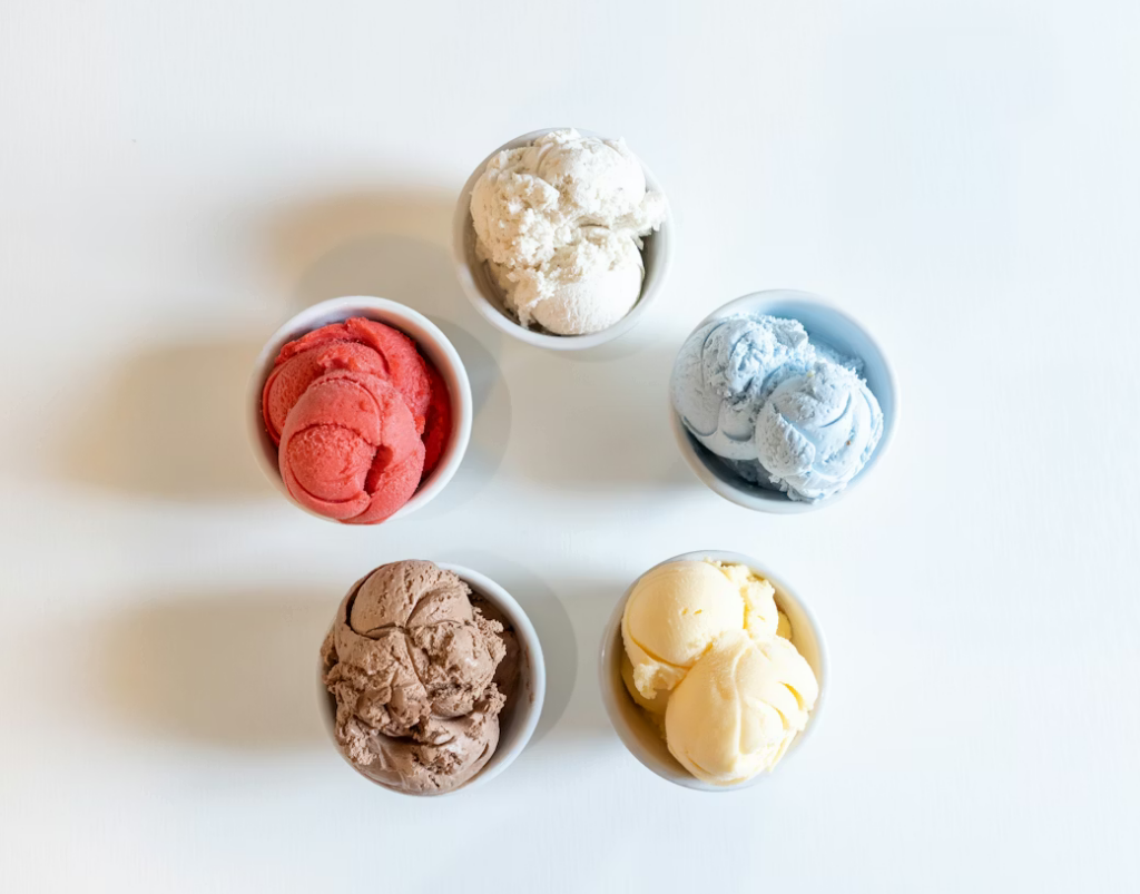 Five bowls of different ice cream flavors arranged in a circle, seen from above.