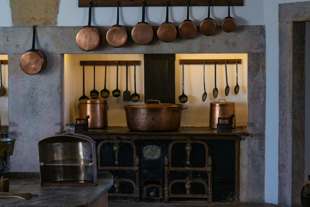 Vintage kitchen with copper pots hanging above a cast iron stove.