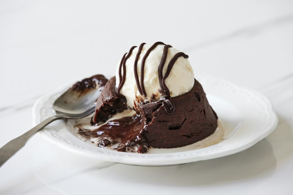 Chocolate lava cake with molten center, topped with vanilla ice cream and chocolate drizzle.