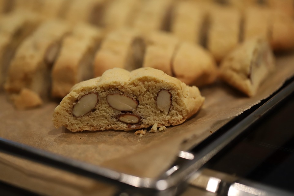 Almond biscotti broken open on a parchment-lined baking sheet.