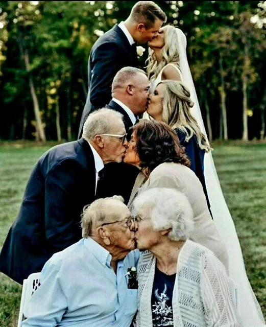 hree generations of couples kiss in a stacked wedding portrait, with the bride and groom at the top, a middle-aged couple in the center, and an elderly couple at the bottom.