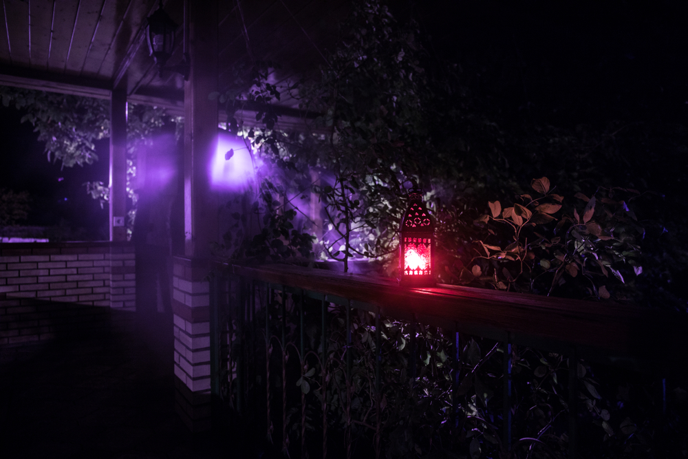 Retro style lantern at night. Beautiful colorful illuminated lamp at the balcony in the garden. Selective focus