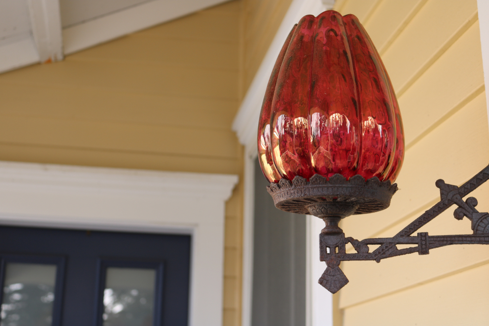 Glass lantern hanging on side of old Victorian home 