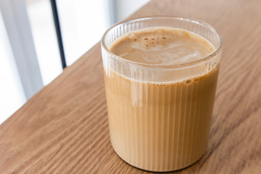 coffee milk on a wooden table in a corner of a room. morning coffee drink concept. Front view