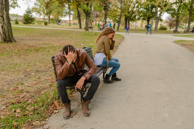 unhappy couple sittong on park bench