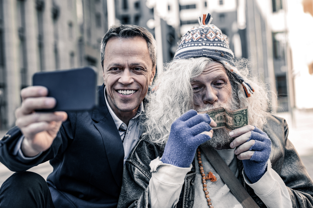 Dollar bill. Wild grey-haired dirty man being focused on money in his hands while unpredictable pedestrian making selfie