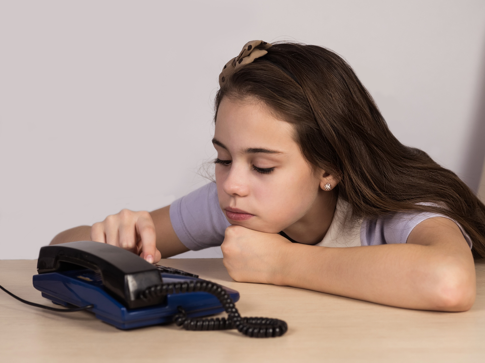 Teenage girl and old retro telephone, USSR. An ancient apparatus.