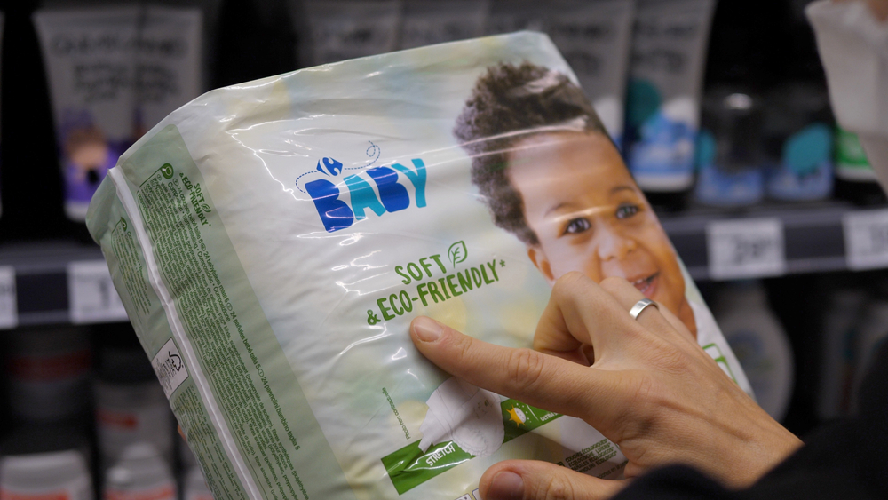 Close up of two female hands holding a pack of eco-friendly baby napkins in store. Family shopping concept. Warsaw-Poland-2020