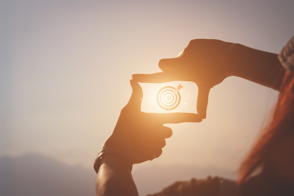 Planning and vision concept of new year's start, woman hands making frame gesture find focus at sunset, woman looking for perspective to capture the meaning of a clear upcoming target.