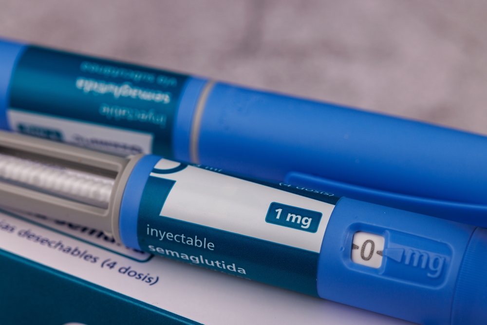 Close-up of a glucose control pen containing semaglutide for diabetes management, displayed on a textured cement table background