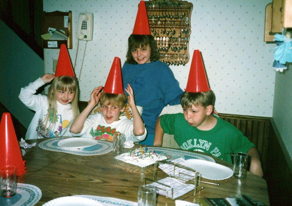 Minneapolis, Minnesota - Circa 1991: Children at a family birthday party, wearing traffic cones on their heads. Funny authentic vintage photo, may have imperfections