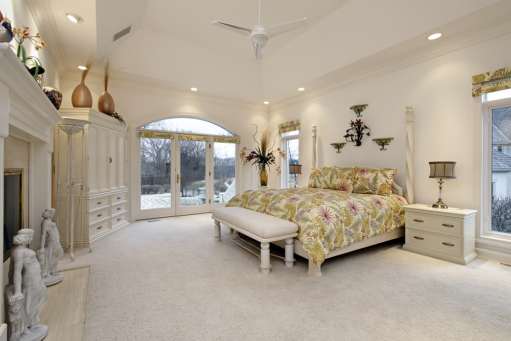 Master bedroom in luxury home with white fireplace
