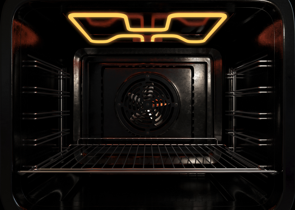 An upclose view of the inside of an empty operational household oven with a glowing element and metal rack - 3D render