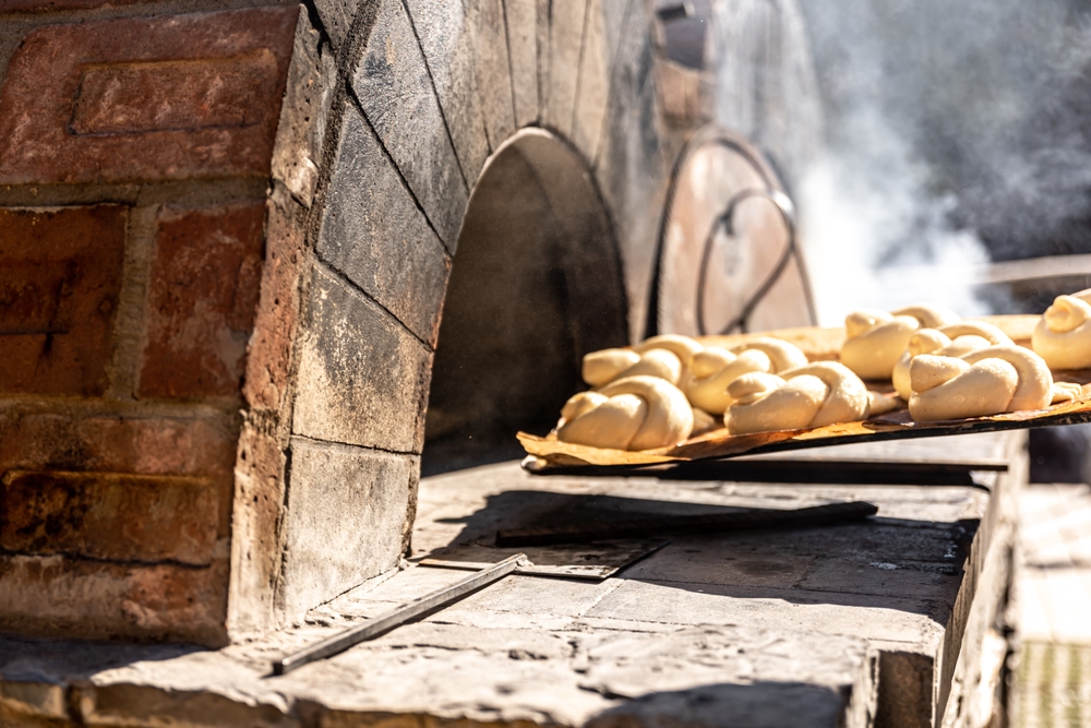 Baking buns in a traditional old oven outside.