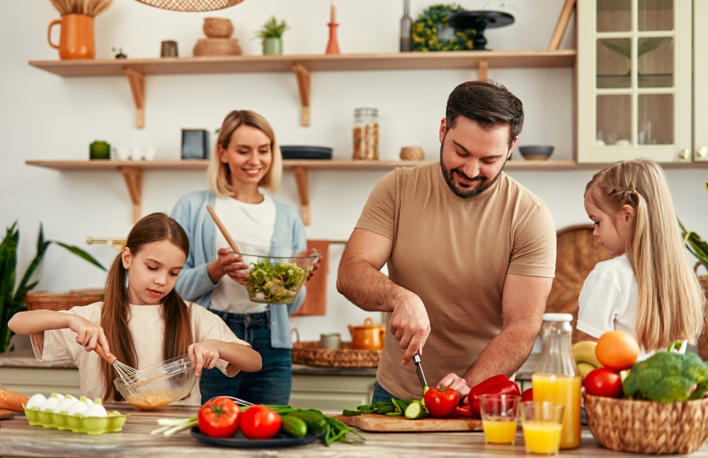 A happy family is cooking together in a bright kitchen, showing joy, teamwork, and love for homecooked meals, creating a warm and loving atmosphere at home