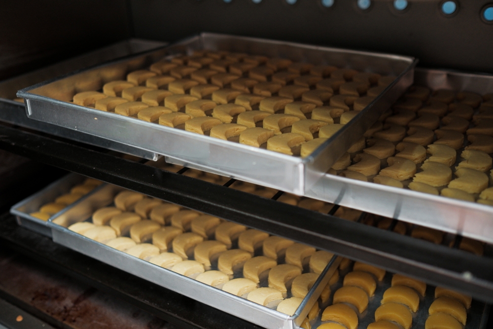 Cookies baking in an oven. Baking tray with tasty homemade cookies taking out from oven
