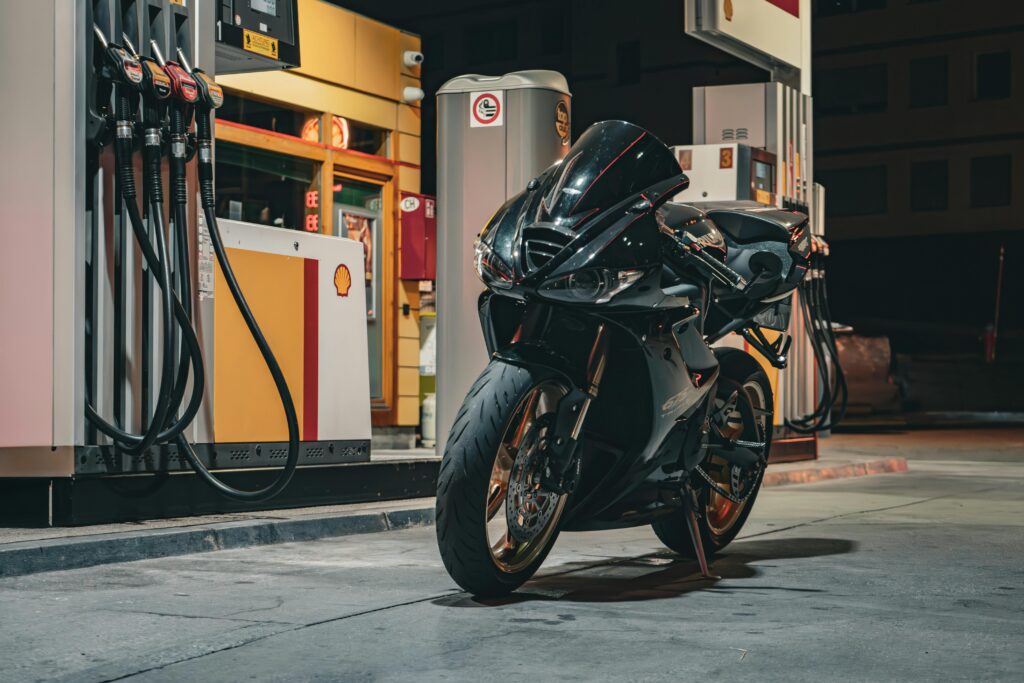 Black Triumph Daytona 675 Motorcycle Parked at the Pump of a Shell Gas Station