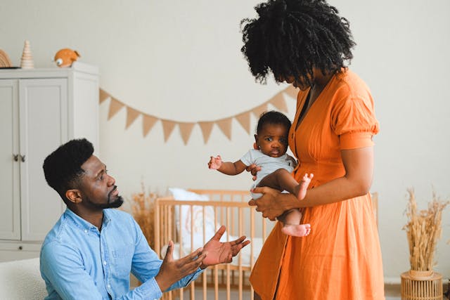 Mother handing baby to father