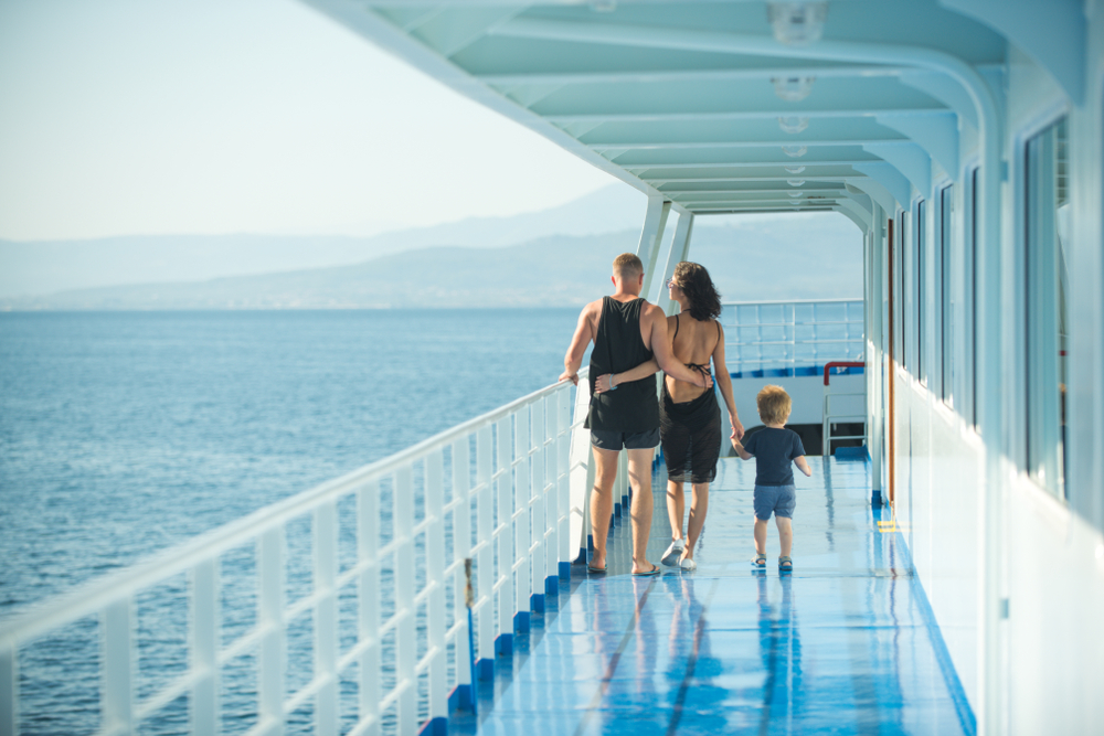 family with son walking on cruise liner deck, full body