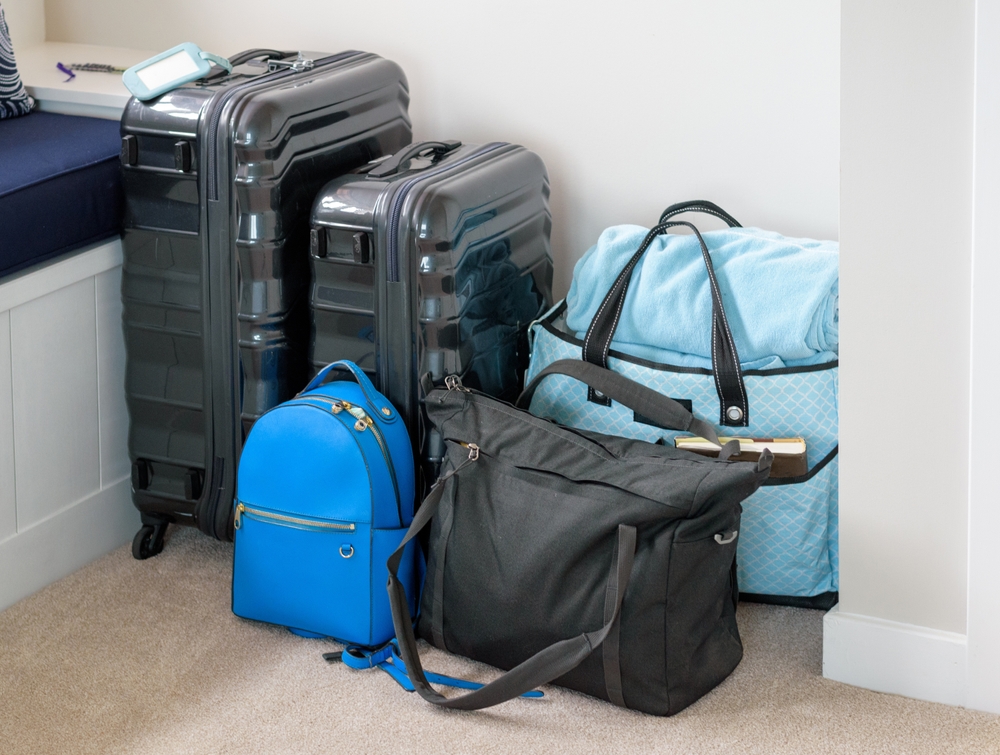 Suitcases, Backpack, Computer Bag, and Beach Bag Luggage Stacked and Ready to Travel