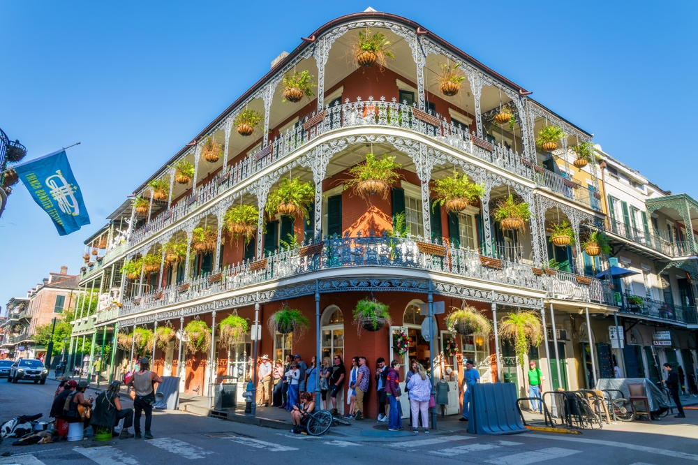 NEW ORLEANS, LOUISIANA - APRIL 8, 2025: Music band, French Quarter Festival flag and historical LaBranche building with balconies and ironwork columns on April 8, 2025 in New Orleans, Louisiana