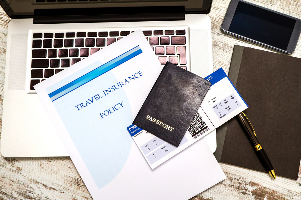 Travel insurance policy booklet with a boarding pass and a passport
