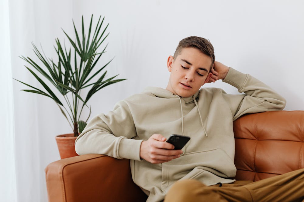 teen on phone sitting in chair