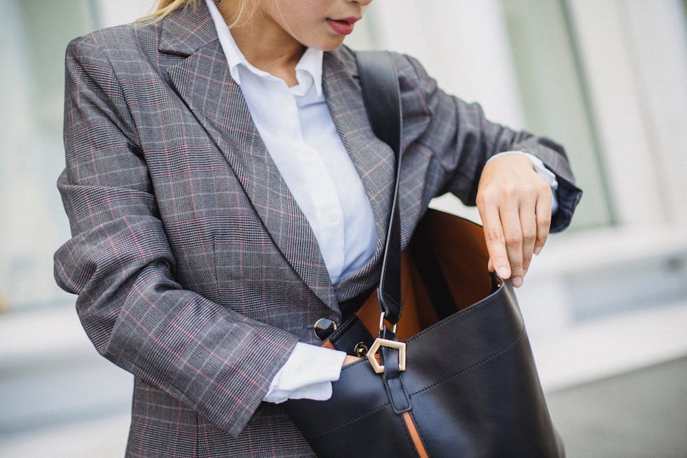 A Woman in a Plaid Blazer Searching Her Leather Bag