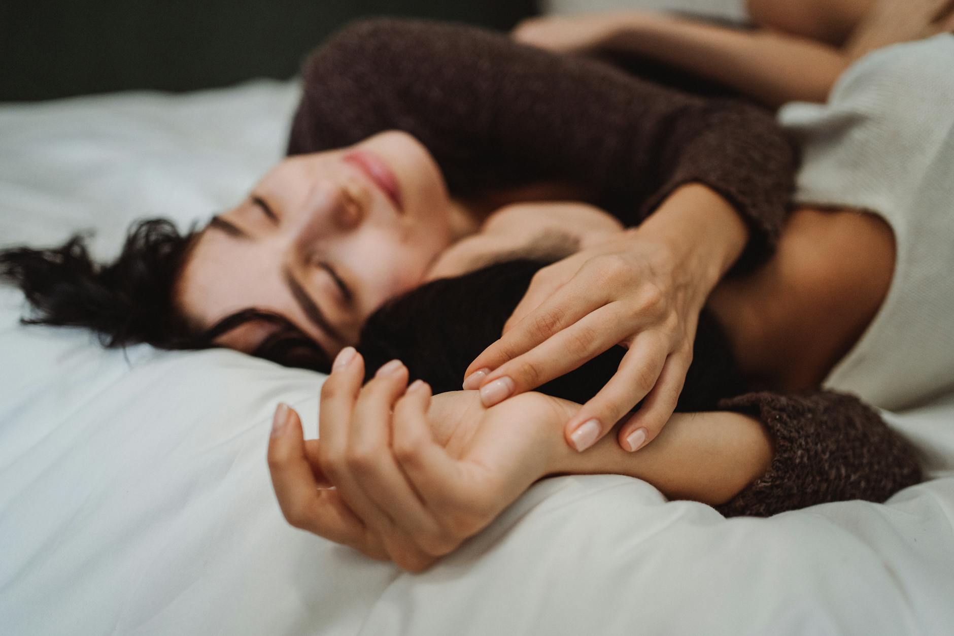 Close-up of a couple embracing on a bed, conveying warmth and intimacy in a peaceful setting.