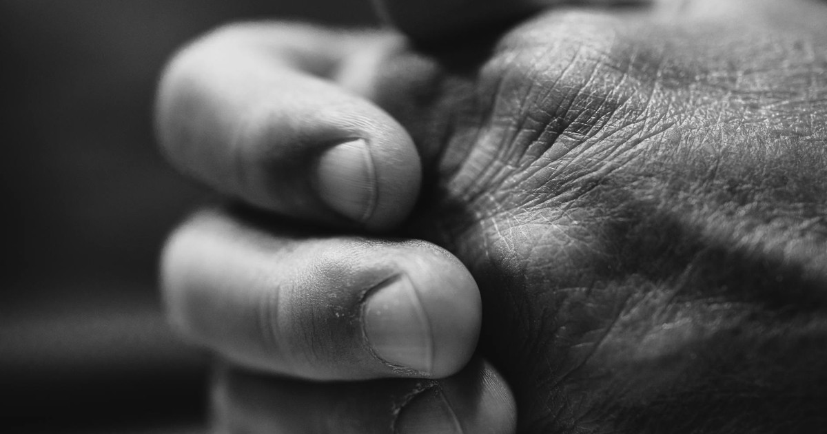 Detailed black and white close-up of clasped hands demonstrating texture and emotion.