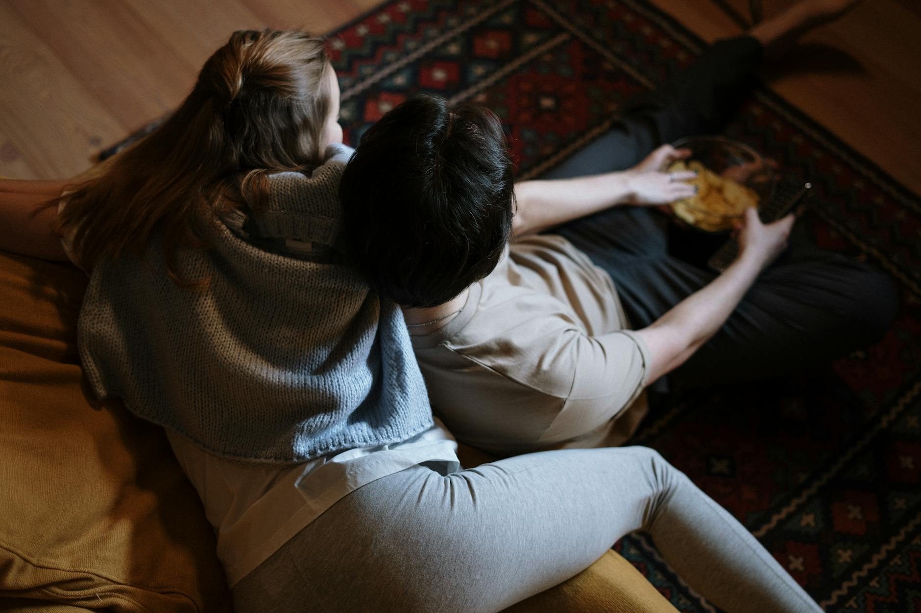A couple relaxing on their couch at home, enjoying a quiet evening together indoors.