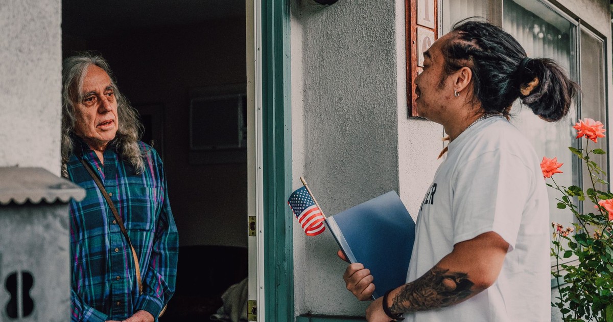 A volunteer engages with a resident during a door-to-door campaign, fostering community interaction.