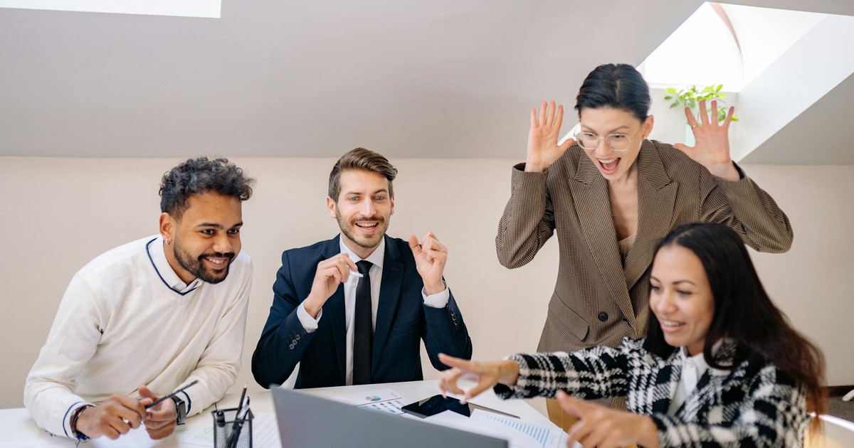 Happy diverse team of colleagues celebrating success in a modern office setting.