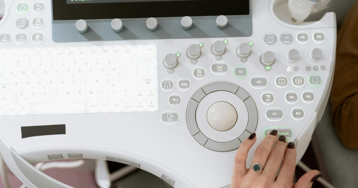 Close-up of a medical professional operating modern ultrasound equipment for diagnosis.