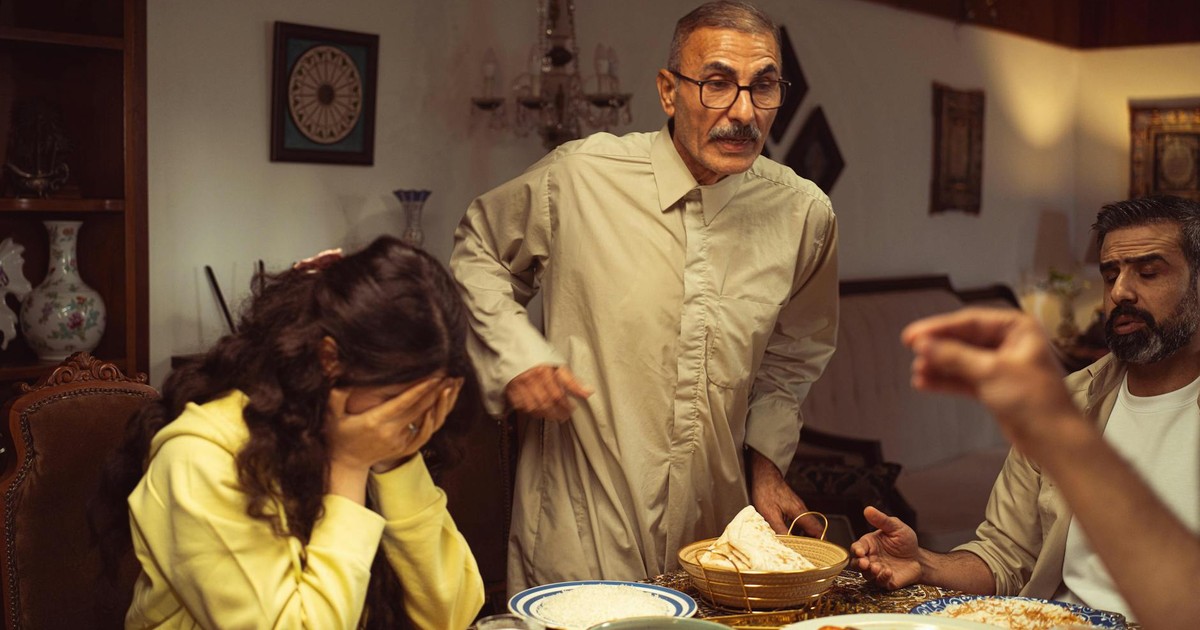 A family gathered around a dining table having an intense emotional exchange.
