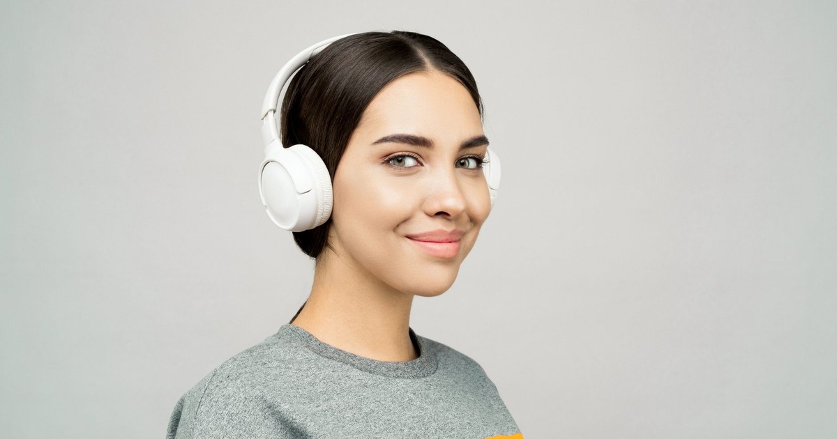 A happy woman listening to music with wireless headphones, showcasing a relaxed and joyful vibe.