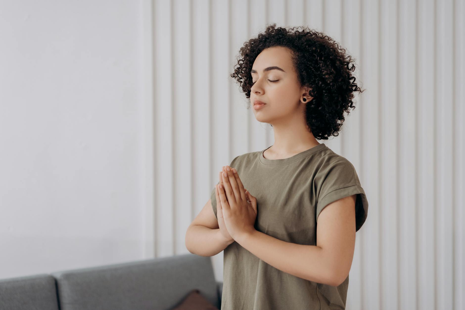 Young woman meditating indoors, practicing mindfulness and relaxation. Peaceful and serene atmosphere.