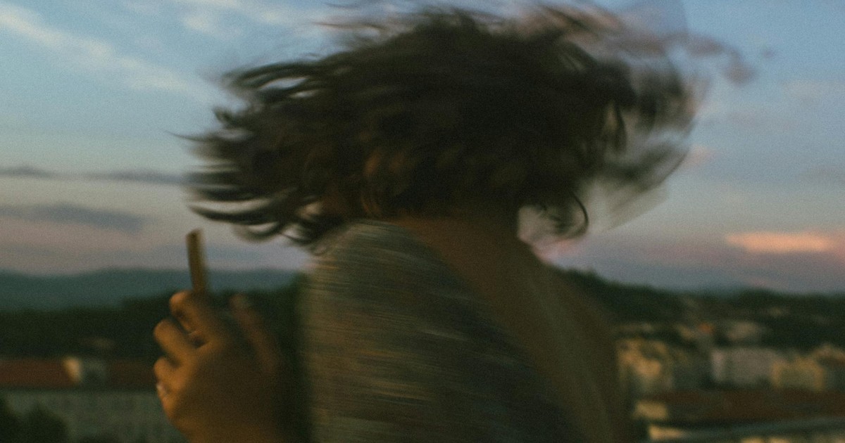 Artistic blurred motion of a woman spinning outdoors at sunset.