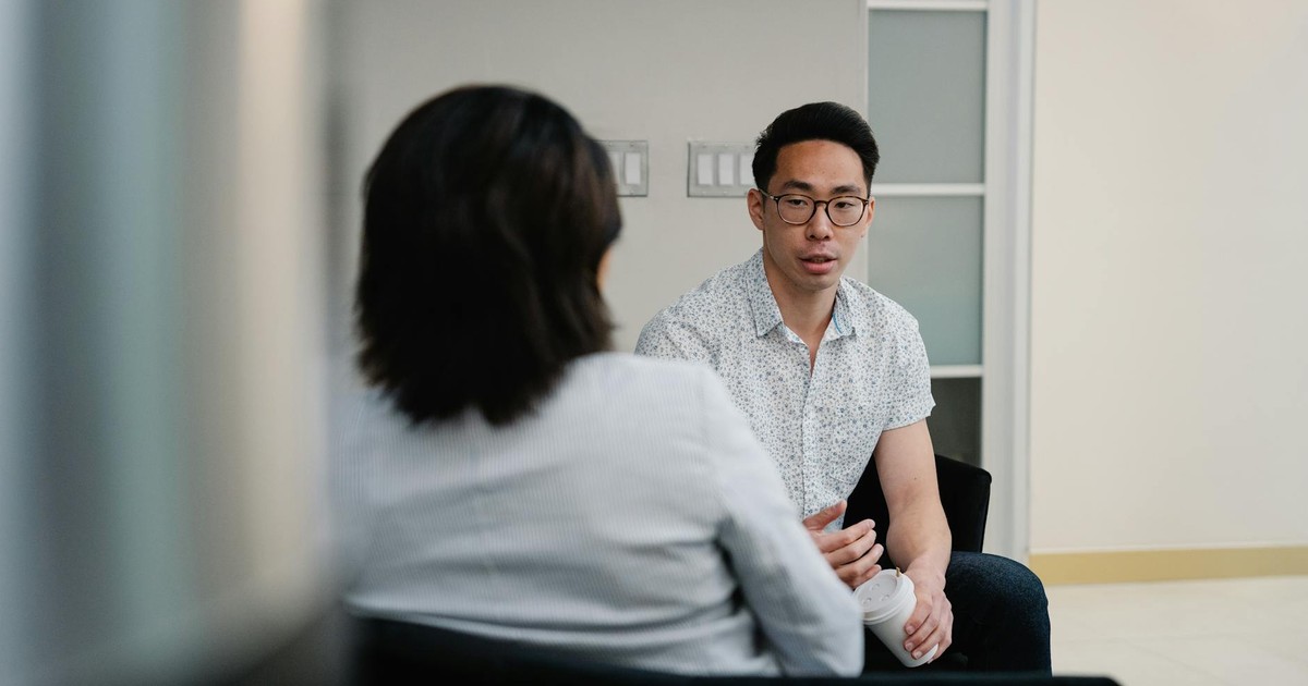 Two colleagues having a focused conversation in an office setting.