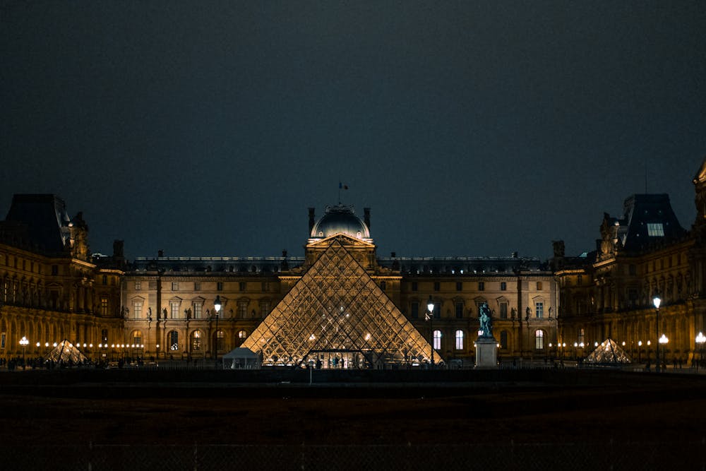 Discover the iconic Louvre Pyramid glowing against the Paris night sky