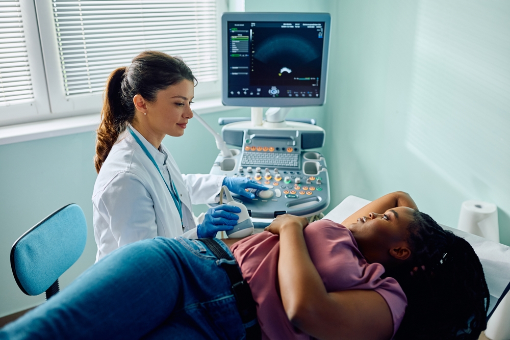 African American mid adult woman during ultrasound examination at doctor's office.