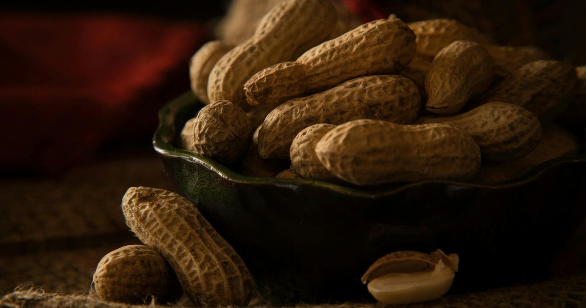 A bowl full of organic peanuts in their shells, perfect for healthy snacking.