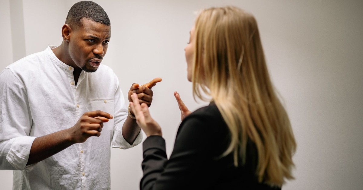Two colleagues engaged in a heated discussion indoors, conveying intense emotions.